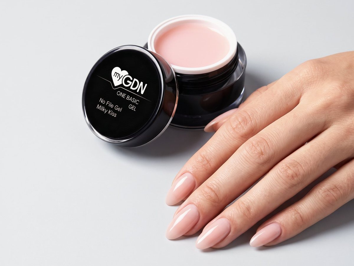 Hand mit Nude-Nägeln neben einem Tiegel No File Gel Milky Kiss